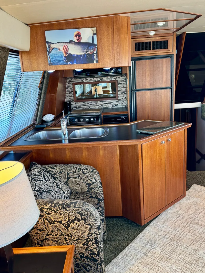 Slide: The Image of Interior of 1994 Bayliner 4788 Pilot House Motoryacht with kitchen and seating area. - 8