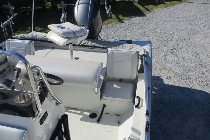 Slide: The Image of 2018 Ranger RB190 Bay boat interior with seating and console, parked on gravel. - 11