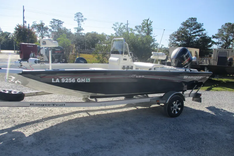 Slide: The Image of 2018 Ranger RB190 Bay boat on trailer, parked outdoors in a sunny setting. - 4