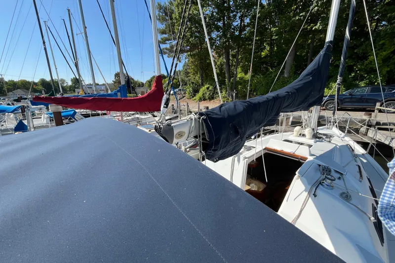 Slide: The Image of Sailboats docked at marina, featuring a 1994 Hunter 29.5 with covered sails. - 11