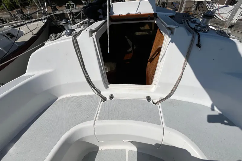 Slide: The Image of 1994 Hunter 29.5 sailboat cockpit with open cabin entrance, featuring winches and ropes. - 12