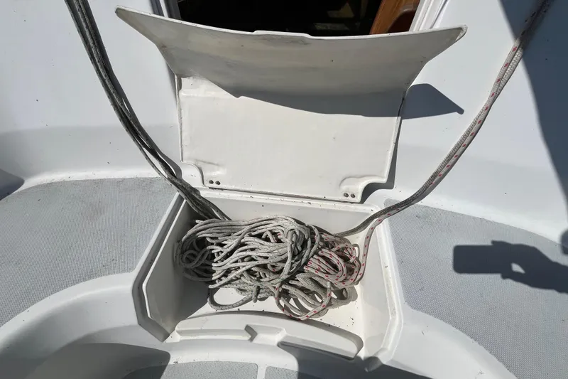 Slide: The Image of Open storage compartment on 1994 Hunter 29.5 sailboat with coiled rope inside. - 13