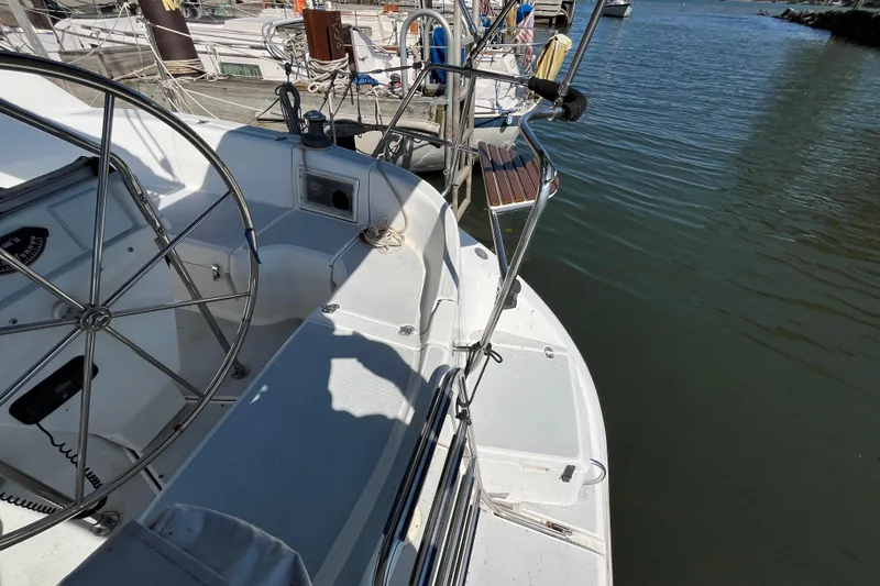 Slide: The Image of 1994 Hunter 29.5 sailboat cockpit with steering wheel, docked at marina. - 18