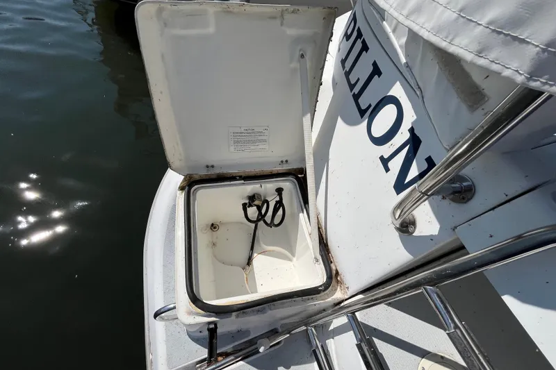 Slide: The Image of Open storage compartment on 1994 Hunter 29.5 boat, docked by water. - 22