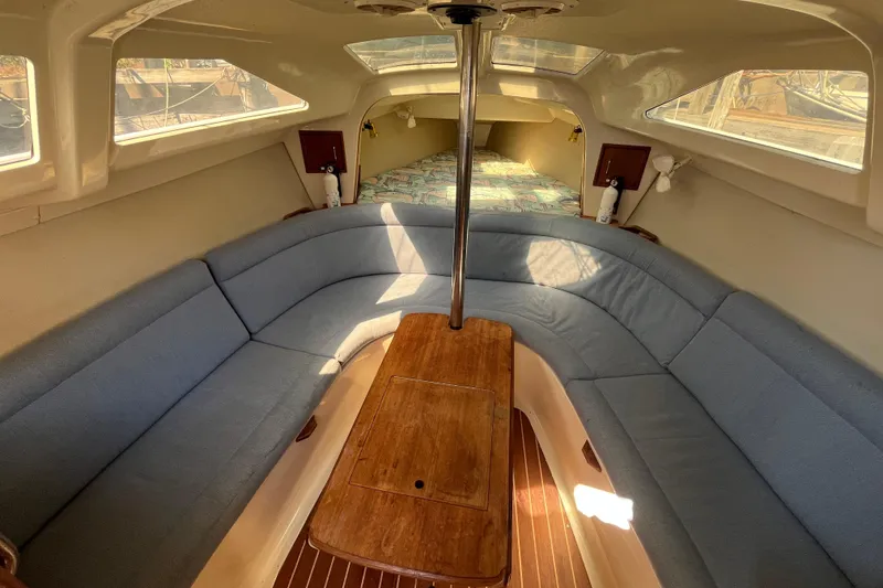 Slide: The Image of Interior of a 1994 Hunter 29.5 sailboat with blue seating and wooden table. - 23