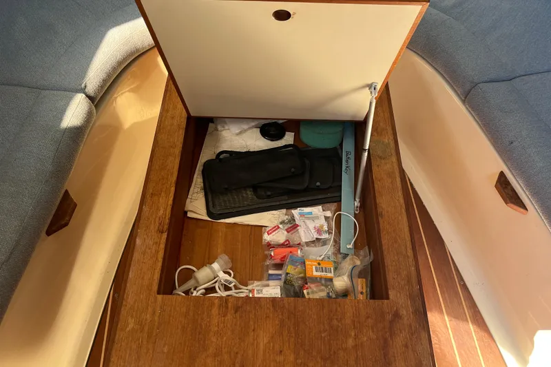 Slide: The Image of Storage compartment in a 1994 Hunter 29.5 sailboat, containing various tools and supplies. - 26