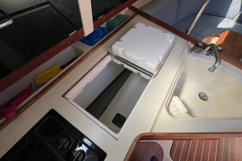 Slide: The Image of 1994 Hunter 29.5 yacht kitchen with sink, stove, and storage compartment. - 32