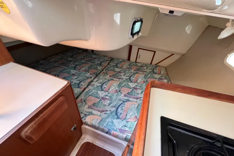 Slide: The Image of Interior cabin of a 1994 Hunter 29.5 sailboat with patterned bedding and compact design. - 35