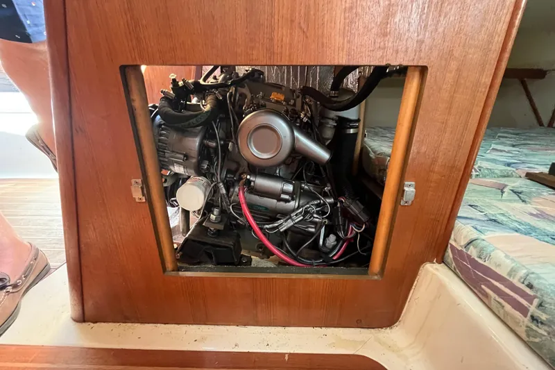 Slide: The Image of Engine compartment of a 1994 Hunter 29.5 sailboat, showcasing detailed mechanical components. - 42