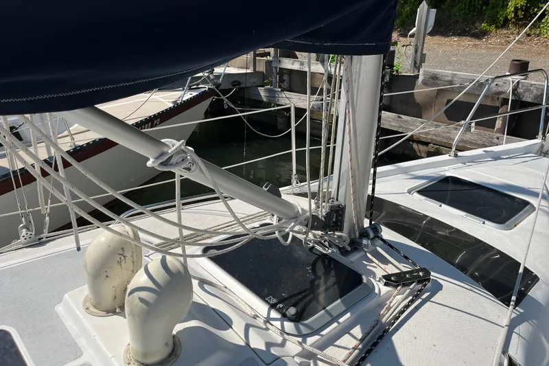 Slide: The Image of 1994 Hunter 29.5 sailboat deck with rigging and hatches in a marina setting. - 7