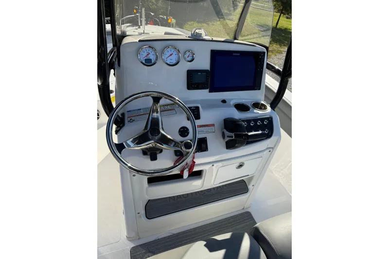Slide: The Image of 2024 NauticStar 231 Hybrid boat console with steering wheel, gauges, and navigation screen. - 5