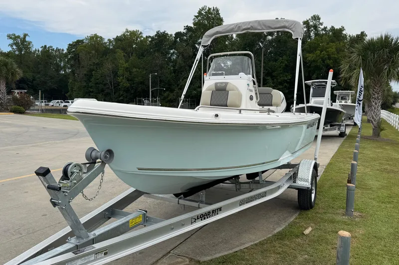 Slide: The Image of 2026 Key West 1720 Center Console boat on trailer, parked outdoors near trees. - 2