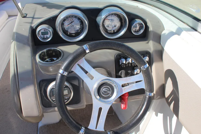 Slide: The Image of Steering wheel and dashboard of 2019 Crownline 205 SS boat, featuring gauges and controls. - 16