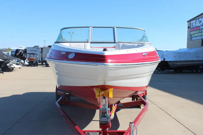 Slide: The Image of 2019 Crownline 205 SS boat on trailer, red and white exterior, parked outdoors. - 2
