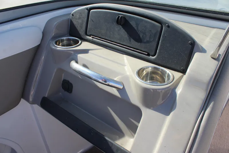 Slide: The Image of 2019 Crownline 205 SS boat interior with cup holders and storage compartment. - 20