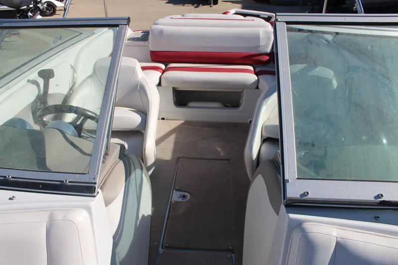 Slide: The Image of 2019 Crownline 205 SS boat interior with white and red seating, steering wheel, and windshield. - 21
