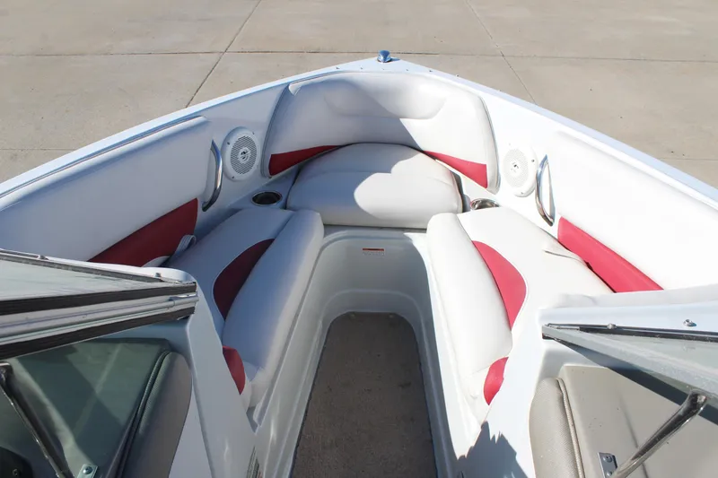 Slide: The Image of 2019 Crownline 205 SS boat interior with white and red seating, cup holders, and speakers. - 22