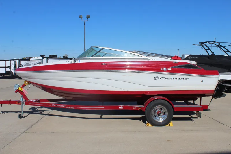Slide: The Image of 2019 Crownline 205 SS boat on trailer, red and white design, parked outdoors. - 4