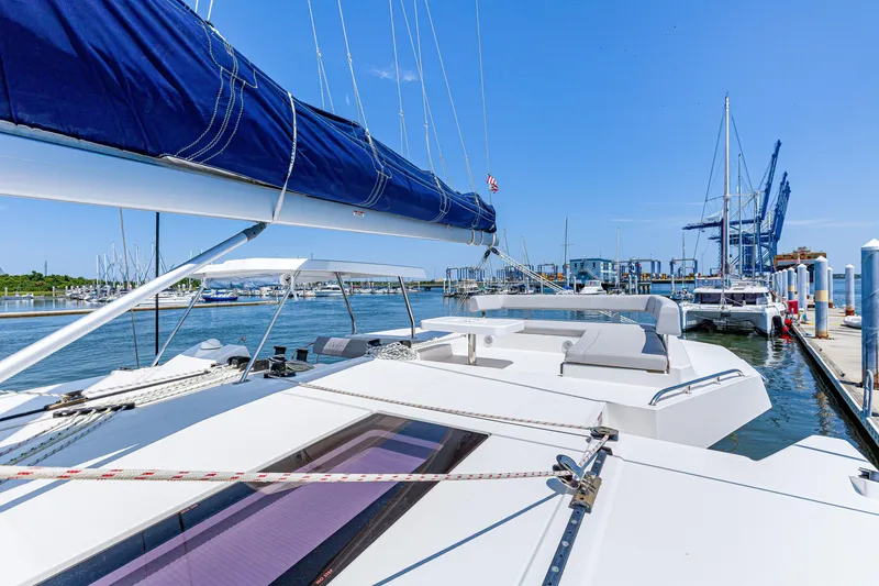 Slide: The Image of 2023 Leopard 42 catamaran docked at marina under clear blue sky. - 6