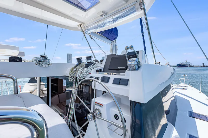 Slide: The Image of 2023 Leopard 42 yacht cockpit with steering wheel and navigation equipment, docked by the sea. - 9