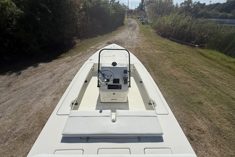 Slide: The Image of 2026 Hewes 18 Redfisher boat on a grassy path, showcasing steering console. - 14