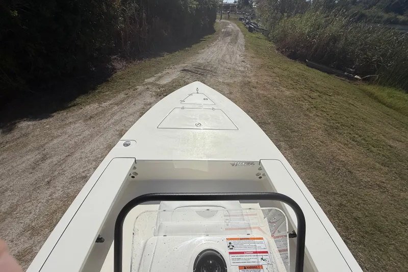 Slide: The Image of 2026 Hewes 18 Redfisher boat on a grassy path, viewed from above. - 16