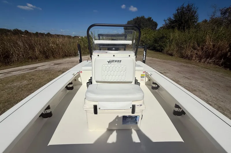 Slide: The Image of 2026 Hewes 18 Redfisher boat interior with seating and console, outdoors. - 18
