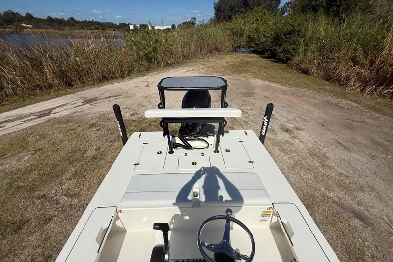 Slide: The Image of 2026 Hewes 18 Redfisher boat on a grassy path near a lake. - 19