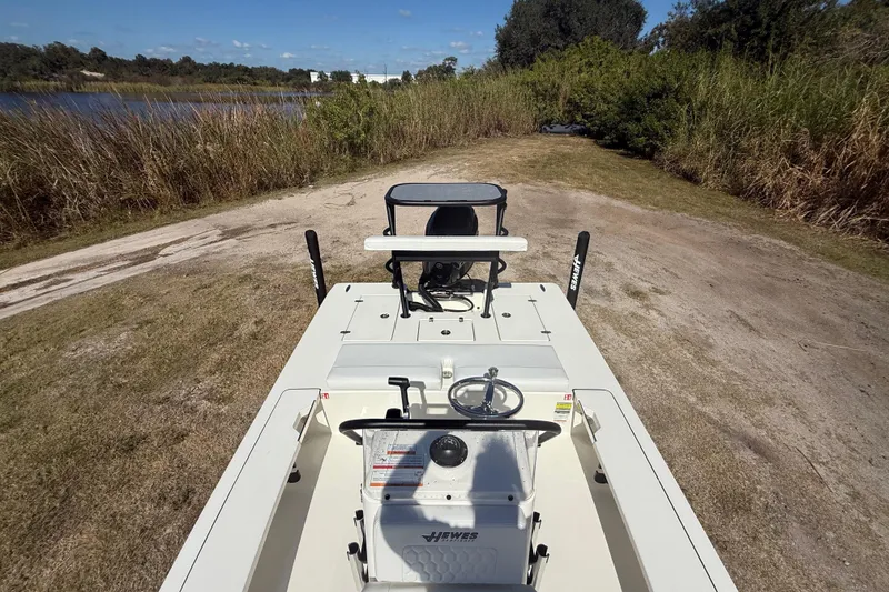 Slide: The Image of 2026 Hewes 18 Redfisher boat on grassy shore near a lake. - 21