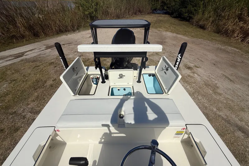 Slide: The Image of 2026 Hewes 18 Redfisher boat interior with open storage compartments and steering wheel. - 24