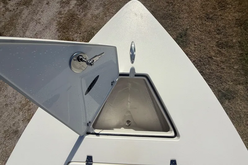 Slide: The Image of 2026 Hewes 18 Redfisher boat with open storage compartment on deck. - 32