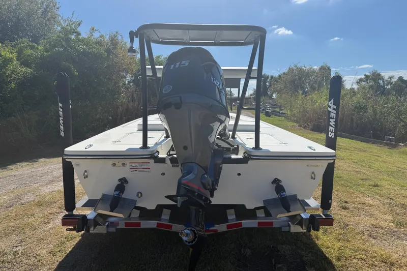 Slide: The Image of 2026 Hewes 18 Redfisher boat with Yamaha 115 engine on trailer, outdoors. - 4