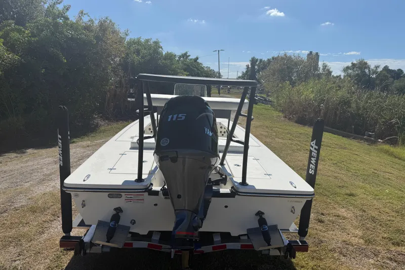 Slide: The Image of 2026 Hewes 18 Redfisher boat with Yamaha 115 engine on trailer, outdoors. - 5