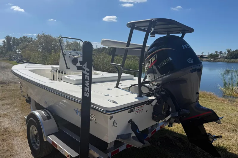Slide: The Image of 2026 Hewes 18 Redfisher boat with Yamaha engine on trailer by a lake. - 6