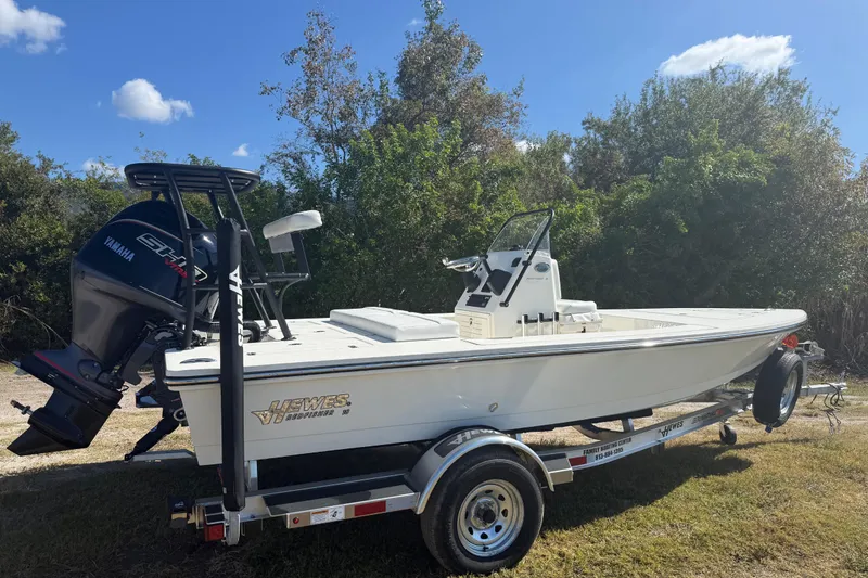 Slide: The Image of 2026 Hewes 18 Redfisher boat on trailer, featuring Yamaha engine, outdoors under blue sky. - 8