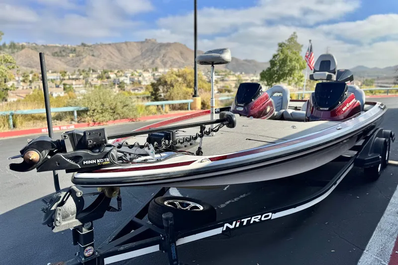 Slide: The Image of 2019 Nitro Z21 fishing boat with Minn Kota motor, parked outdoors, scenic mountain backdrop. - 3