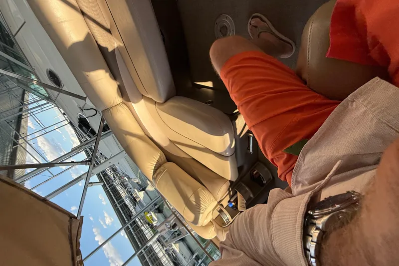 Slide: The Image of Man relaxing on a 2015 Regency 250 LE boat, wearing orange shorts. - 12