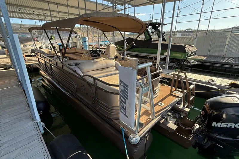 Slide: The Image of 2015 Regency 250 LE pontoon boat docked under a covered marina. - 4