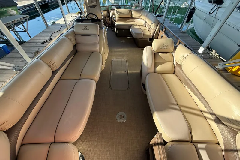 Slide: The Image of Luxurious 2015 Regency 250 LE pontoon boat interior with beige seating and spacious layout. - 5