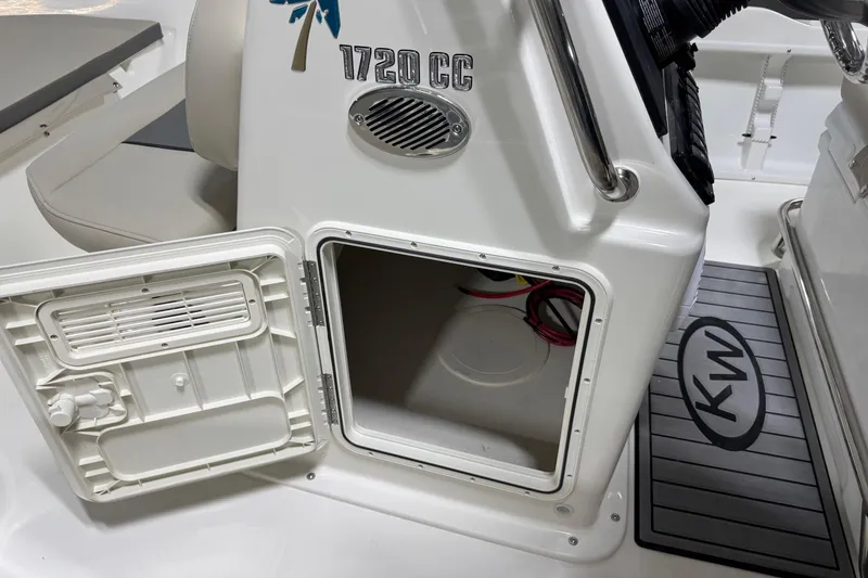 Slide: The Image of Open storage compartment on 2026 Key West 1720 Center Console boat, featuring KW logo mat. - 16