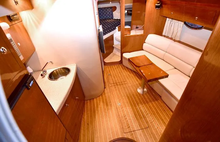 Slide: The Image of Interior of 2006 Regal Commodore 3560 yacht with wood flooring and cozy seating area. - 11