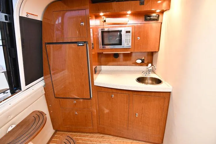 Slide: The Image of 2006 Regal Commodore 3560 yacht kitchen with wood cabinetry, microwave, and sink. - 13