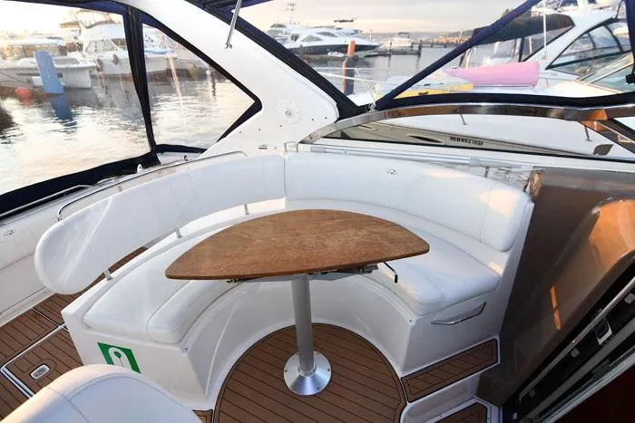 Slide: The Image of 2006 Regal Commodore 3560 yacht interior with white seating and wooden table. - 5