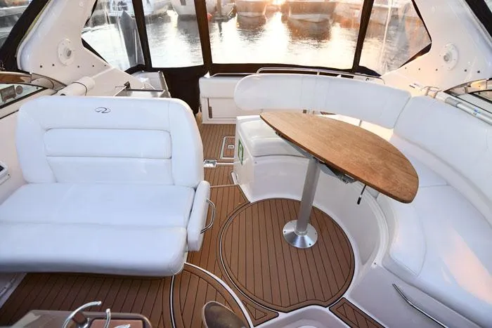 Slide: The Image of Luxurious interior of 2006 Regal Commodore 3560 yacht with white seating and wooden table. - 6