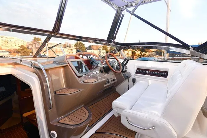 Slide: The Image of 2006 Regal Commodore 3560 yacht cockpit with white seating and wooden accents. - 9