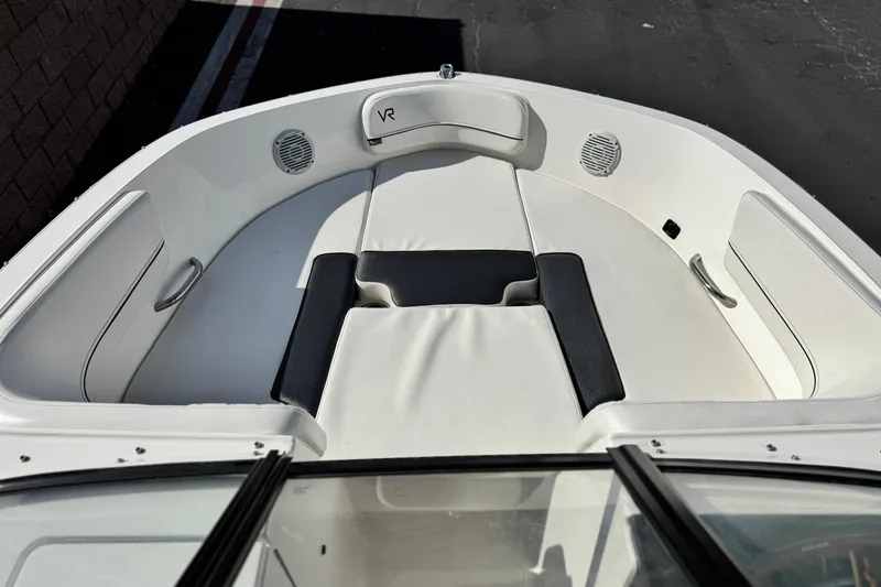 Slide: The Image of 2022 Bayliner VR6 Bowrider OB interior with white seating and speakers. - 11