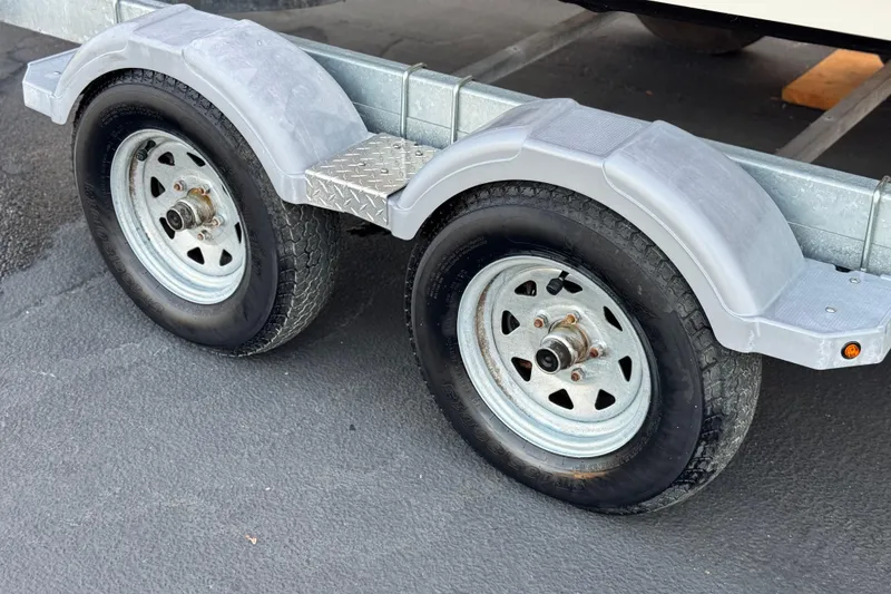 Slide: The Image of Trailer wheels for 2022 Bayliner VR6 Bowrider OB on asphalt surface. - 25