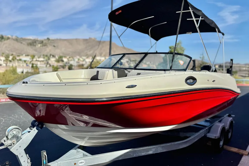 Slide: The Image of 2022 Bayliner VR6 Bowrider OB with red hull on a trailer, scenic background. - 3