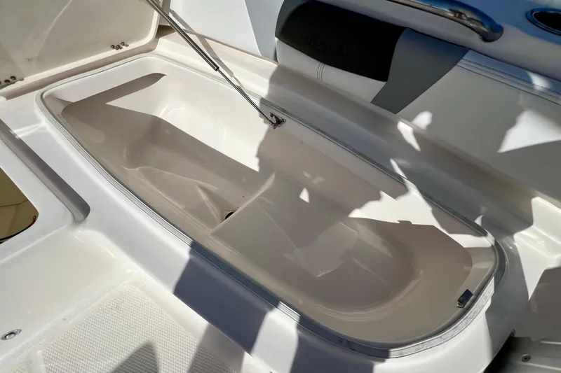 Slide: The Image of 2024 Robalo 206 Cayman boat storage compartment, open and empty, with sunlight casting shadows. - 23