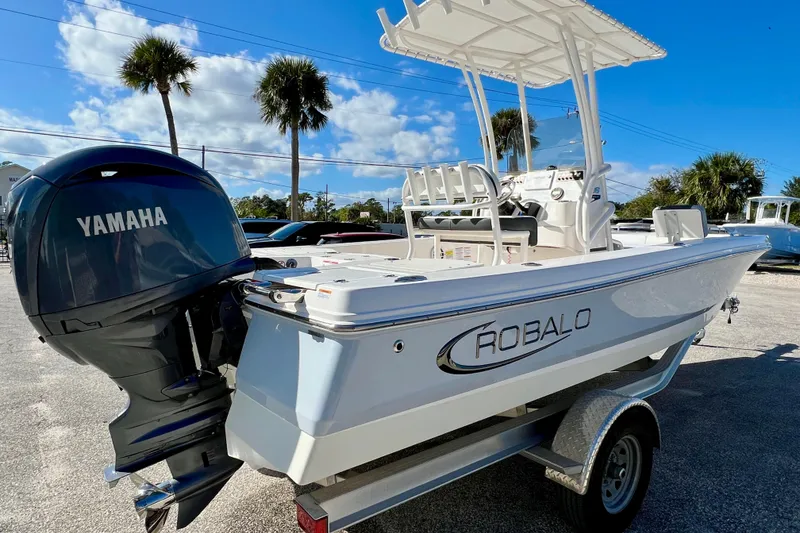 Slide: The Image of 2024 Robalo 206 Cayman boat with Yamaha engine, parked on a trailer under a sunny sky. - 5